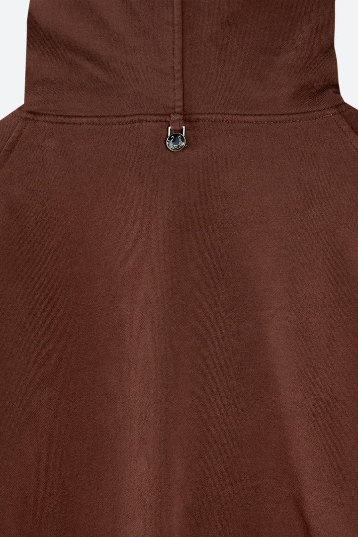 Close-up of a brown fabric with a metal button on a white background