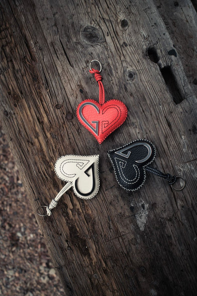 Three heart-shaped keychains on a wooden surface