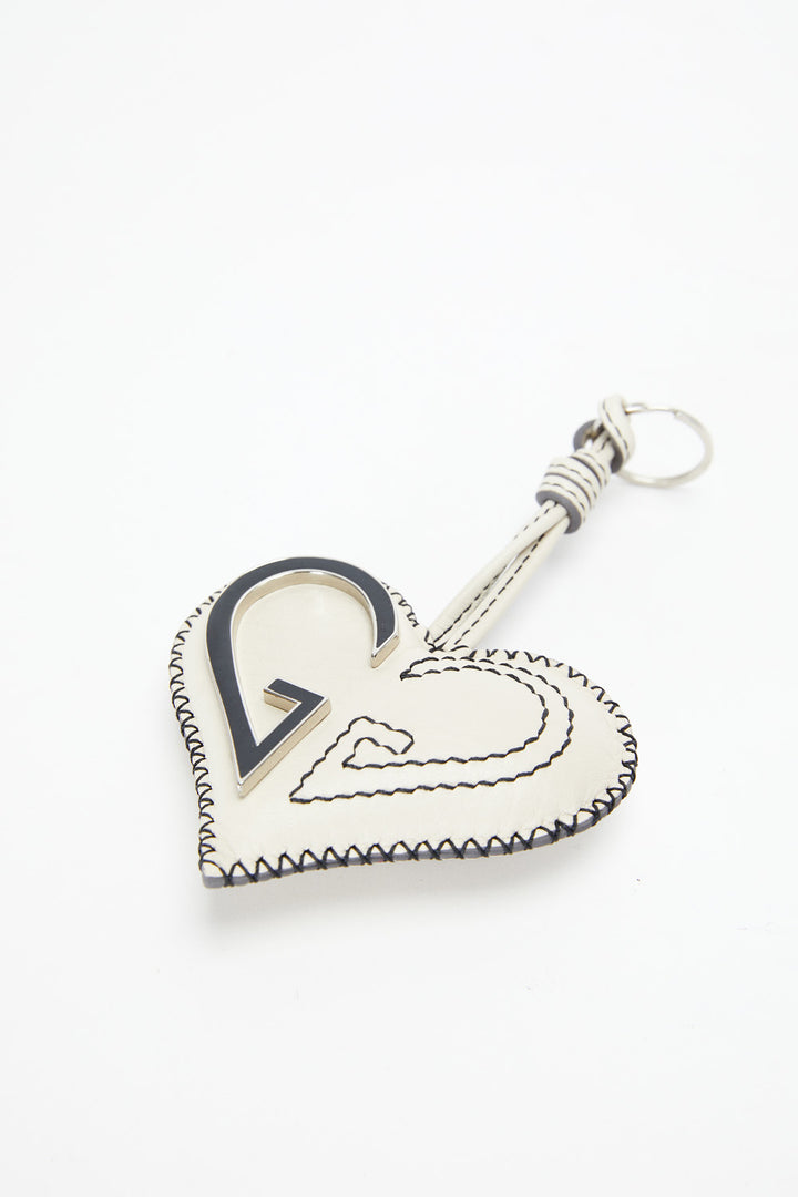 Heart-shaped keychain with a key attached on a white background