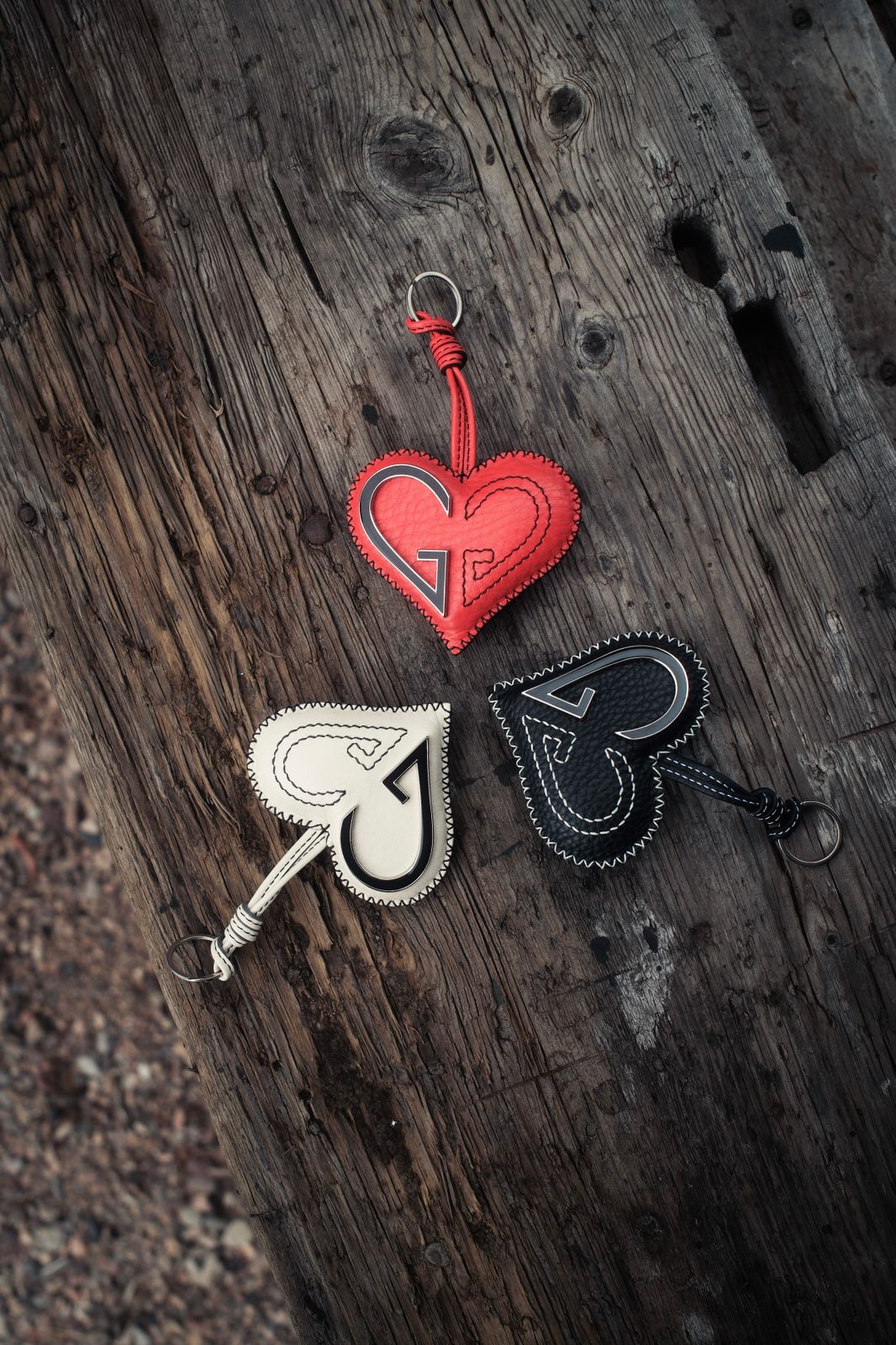 Three heart-shaped keychains on a wooden surface