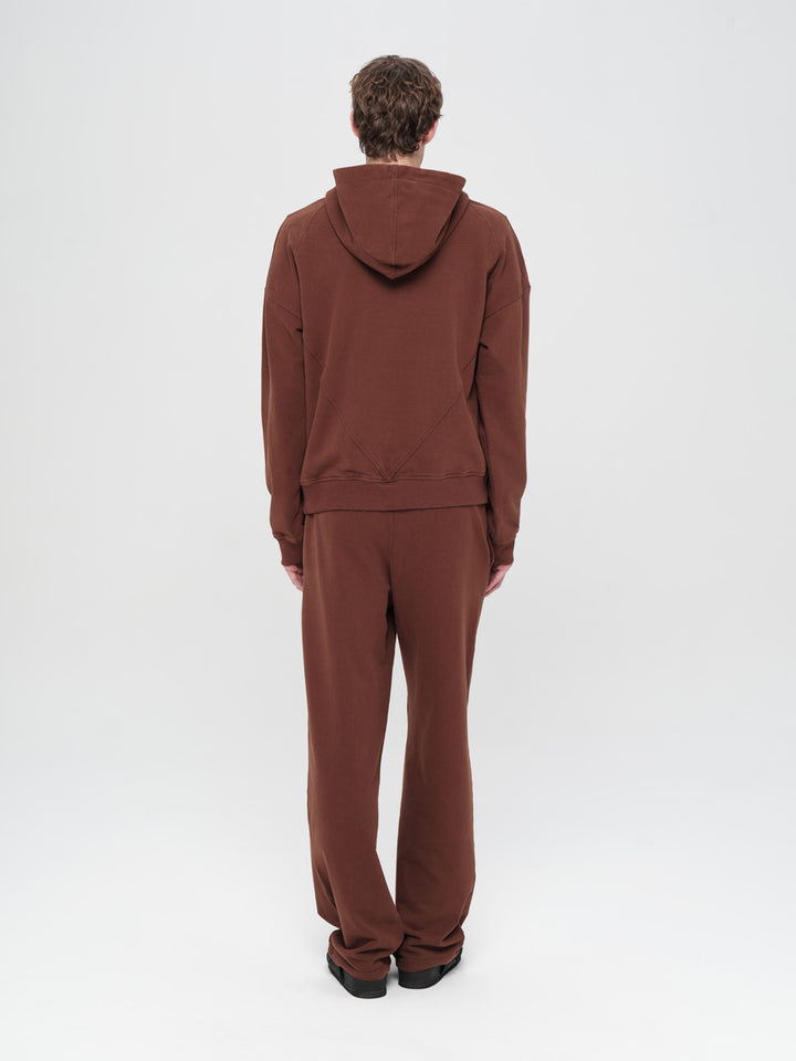 Person wearing a brown tracksuit on a white background