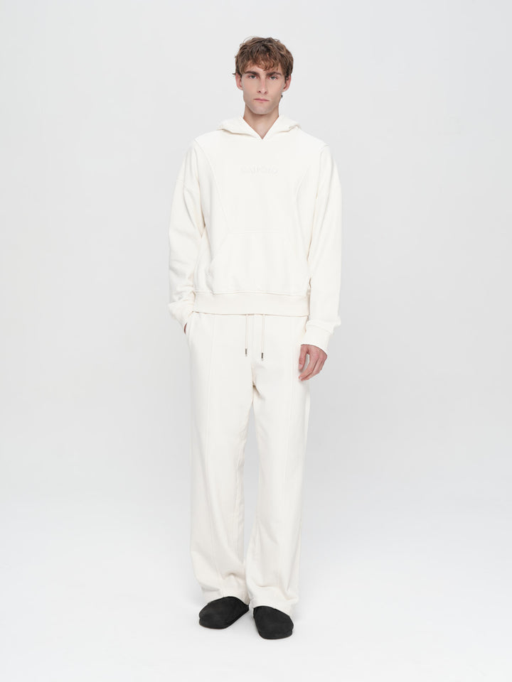 Person wearing a white onesie on a plain background