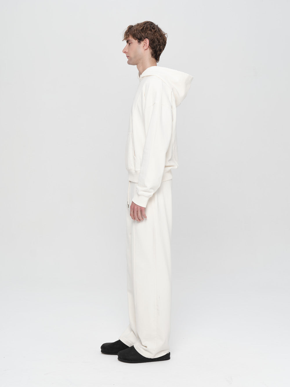 Person wearing a white onesie against a plain background
