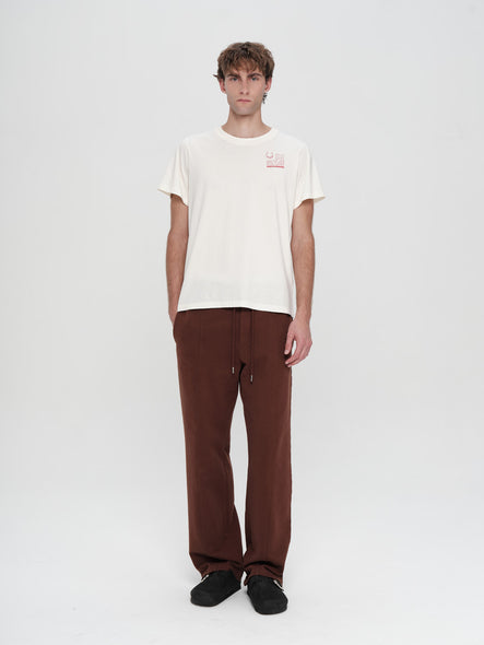 Person wearing a white t-shirt and brown pants on a white background