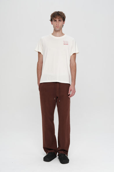 Person wearing a white t-shirt and brown pants on a white background