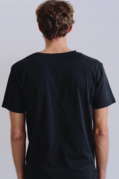 Person wearing a black t-shirt against a plain background