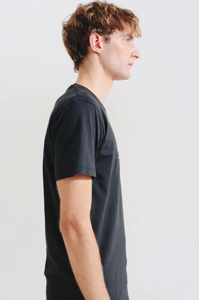 Man wearing a black t-shirt against a plain background