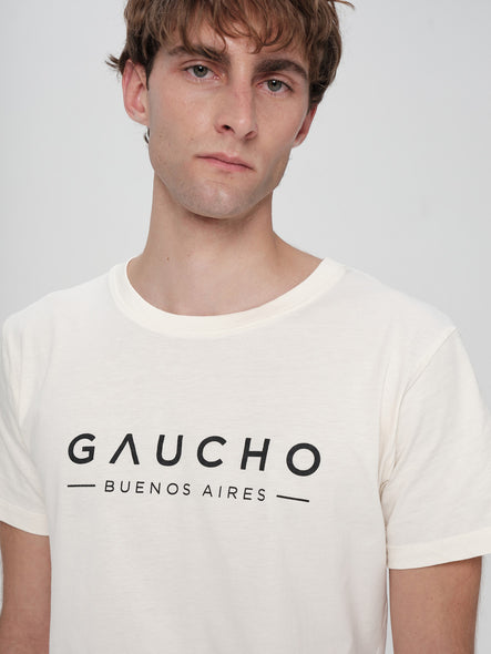 Man wearing a white t-shirt with 'Gaucho Buenos Aires' text on a plain background