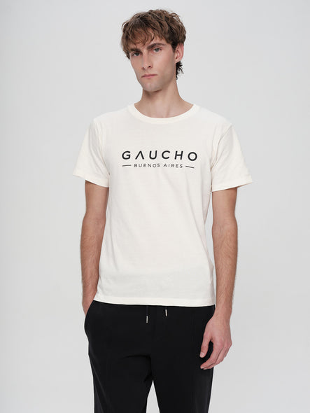 Man wearing a white t-shirt with 'Gaucho Buenos Aires' text on a plain background