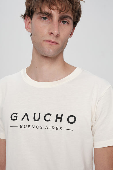 Man wearing a white t-shirt with 'Gaucho Buenos Aires' text on a plain background