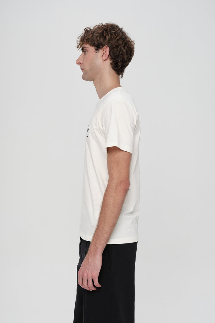 Person wearing a plain white t-shirt on a light gray background