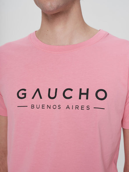 Person wearing a pink t-shirt with 'Gaucho Buenos Aires' text on a plain background
