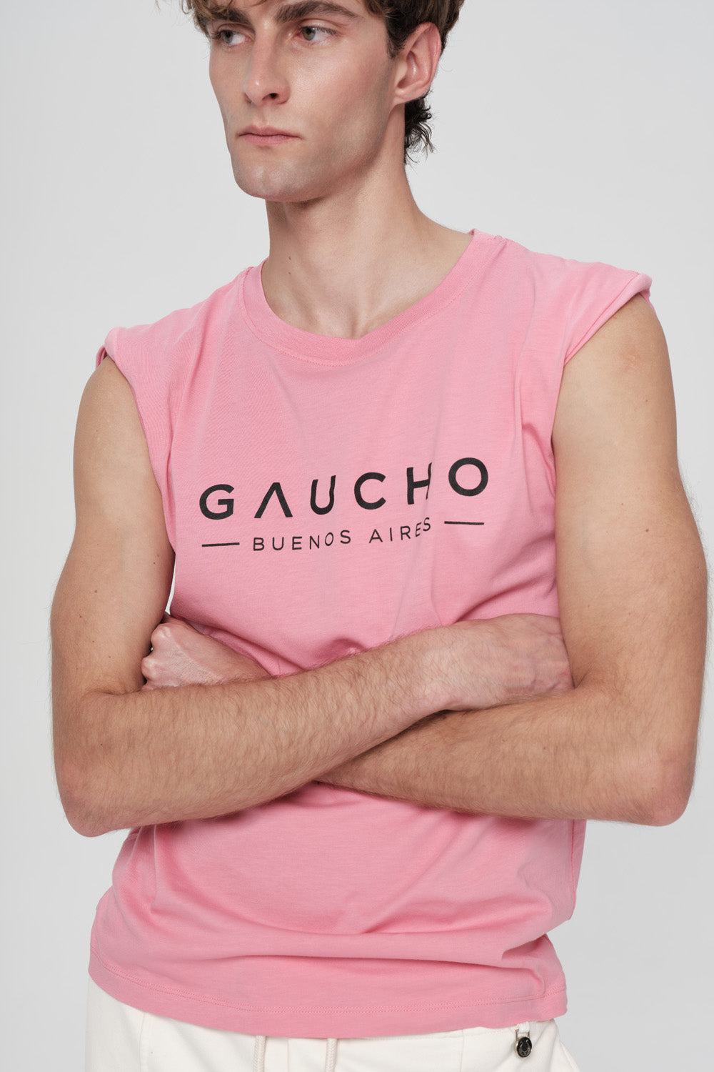 Person wearing a pink sleeveless shirt with 'Gaucho Buenos Aires' text on a white background