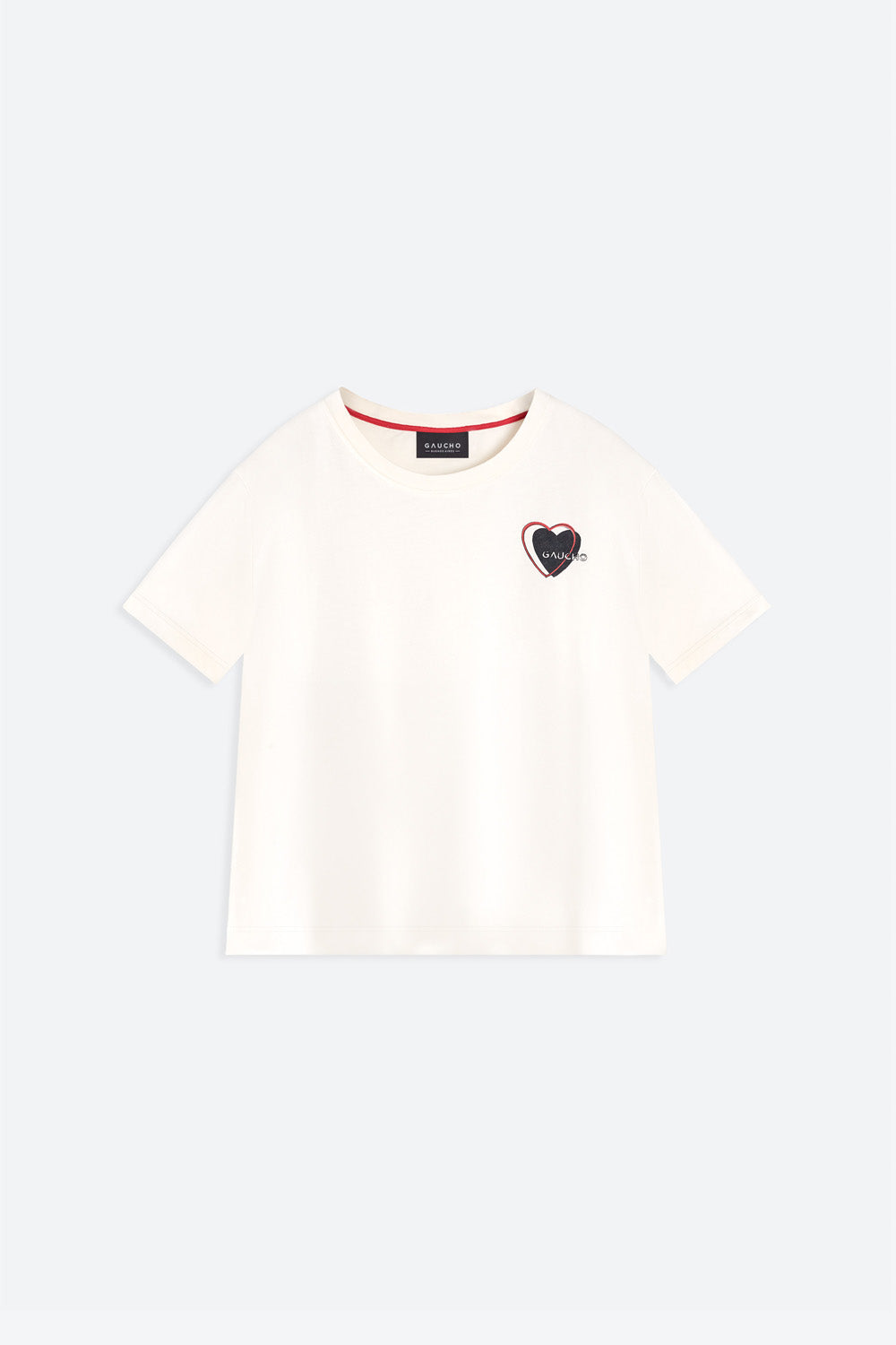 White t-shirt with a small black heart design on a light gray background