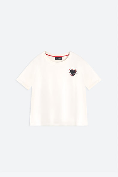 White t-shirt with a small black heart design on a light gray background