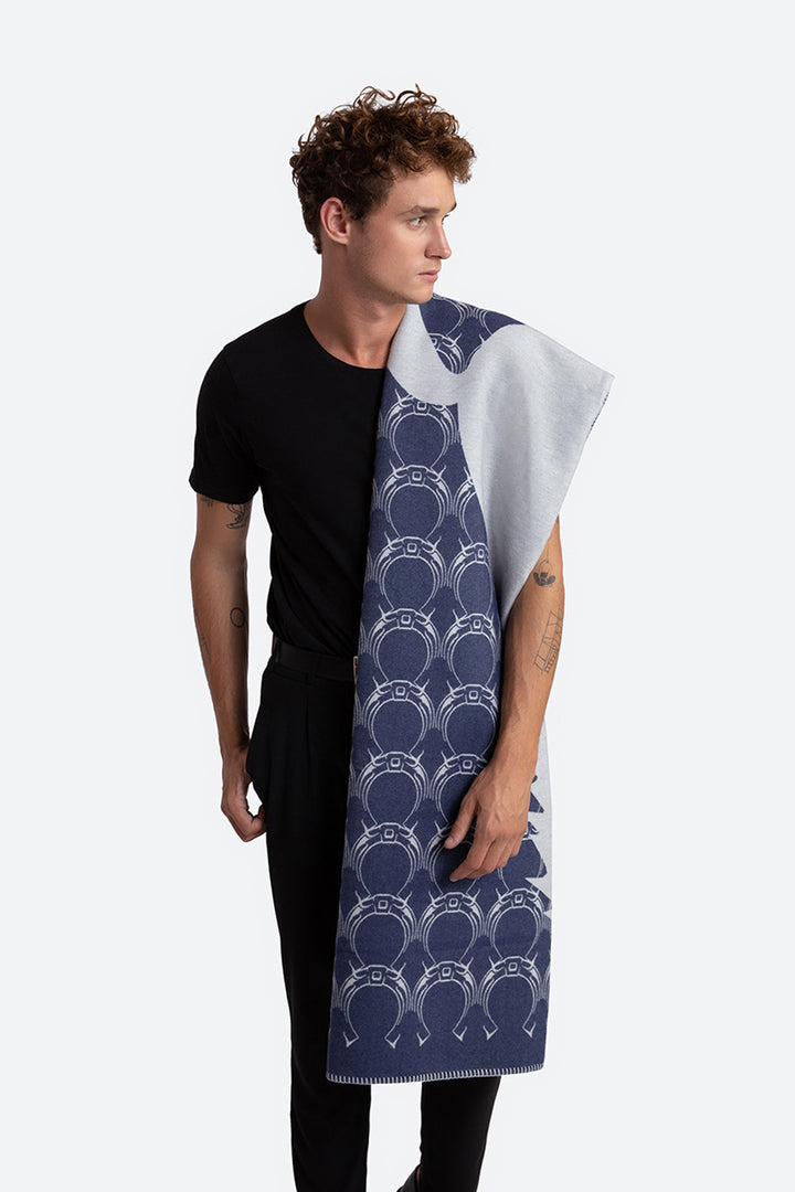 Man holding a patterned blanket with a white and blue design
