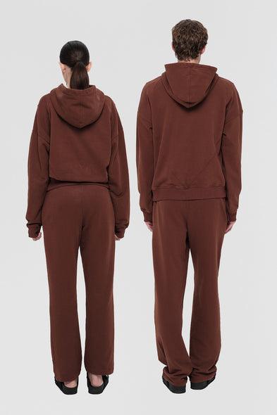 Brown tracksuit worn by a person on a white background