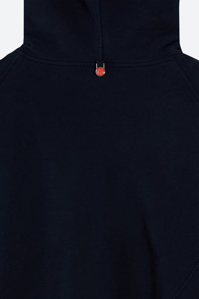 Close-up of a black hoodie with a red pendant on a white background