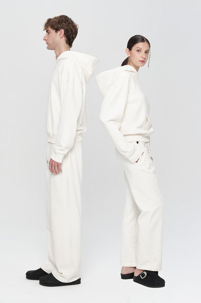 Two people wearing white outfits on a plain background