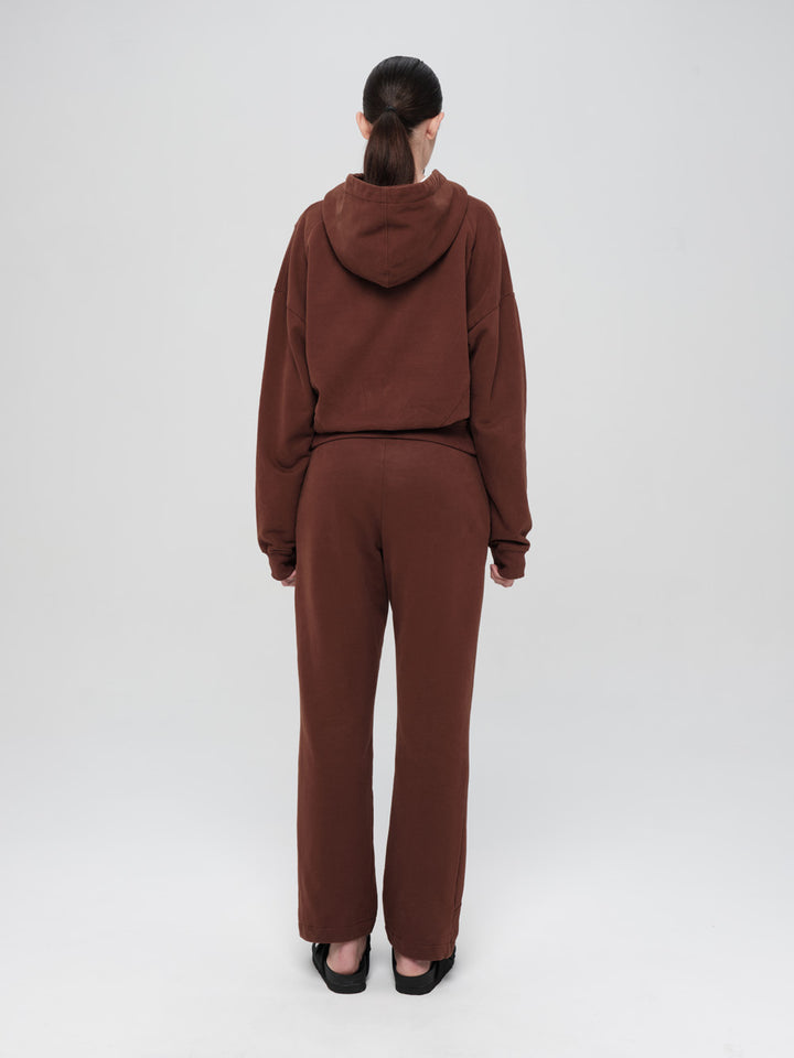 Person wearing a brown tracksuit on a white background