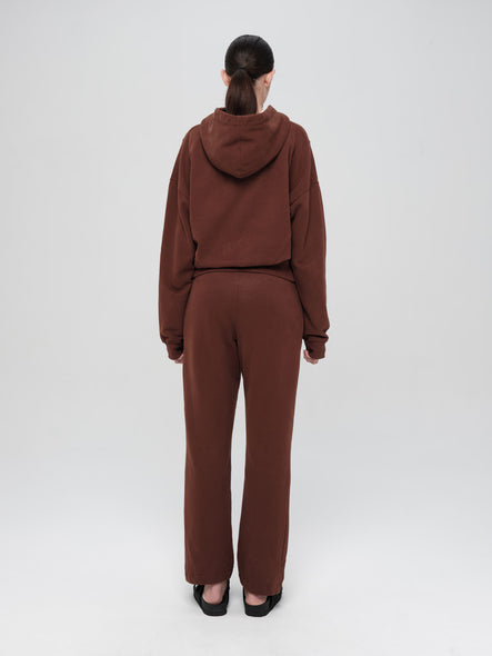 Person wearing a brown tracksuit on a white background