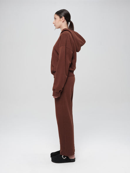 Person wearing a brown tracksuit on a white background