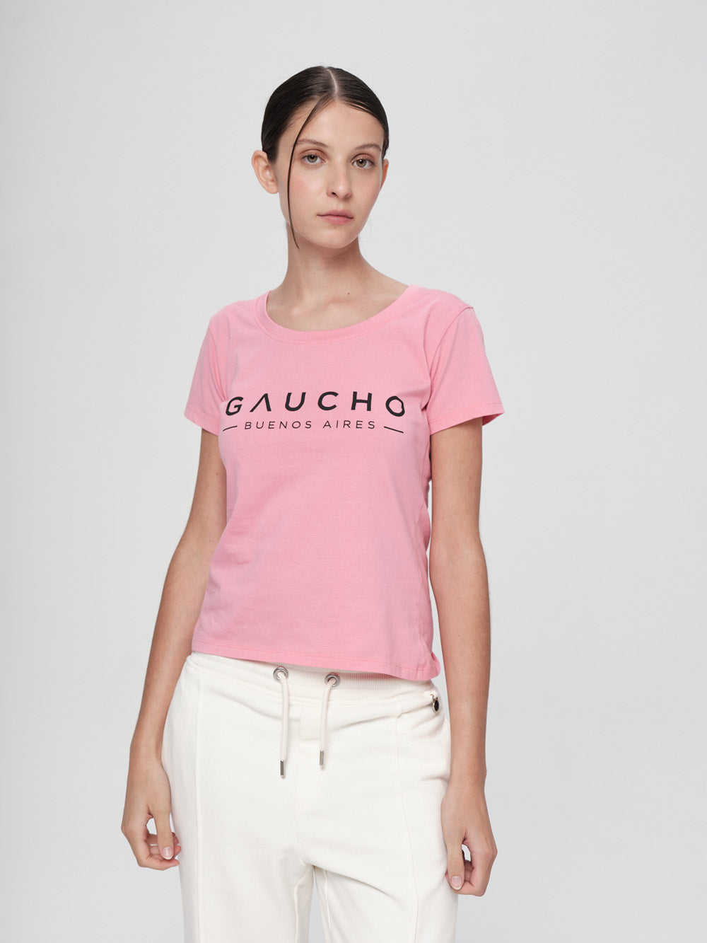 Person wearing a pink t-shirt with 'Gaucho Buenos Aires' text on a white background