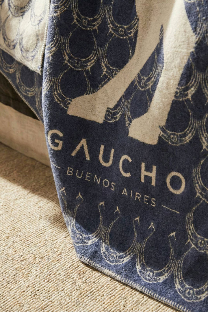 Close-up of a blue and off-white patterned fabric with 'Gaucho Buenos Aires' branding.
