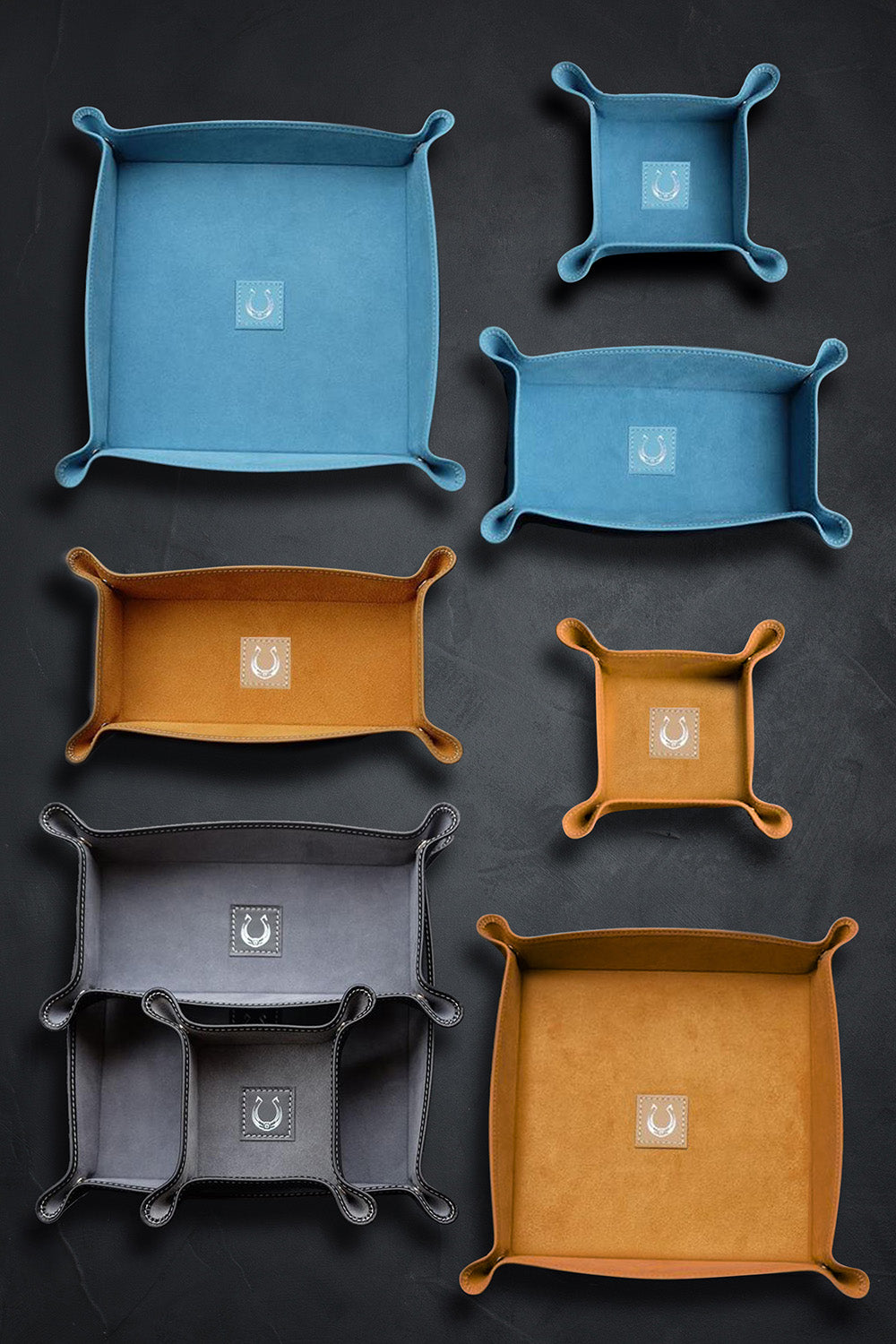 Set of blue, orange, and gray square trays on a dark background