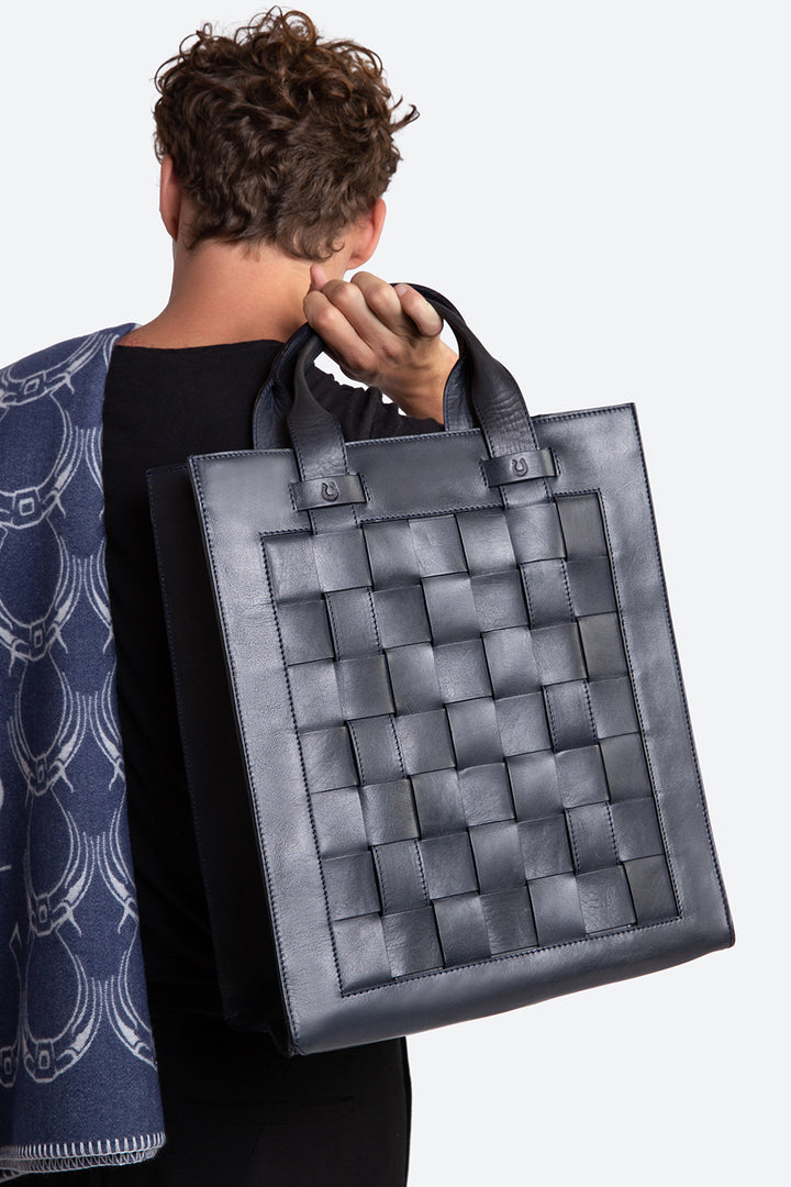 Man holding the Esquel bag in navy.